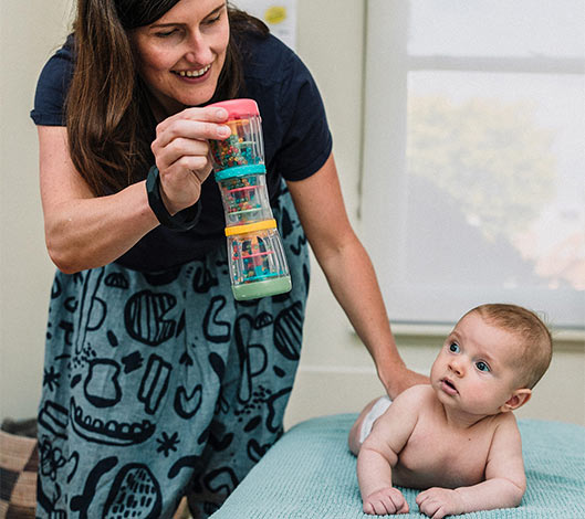 baby looking up at Osteopath for babies rattle